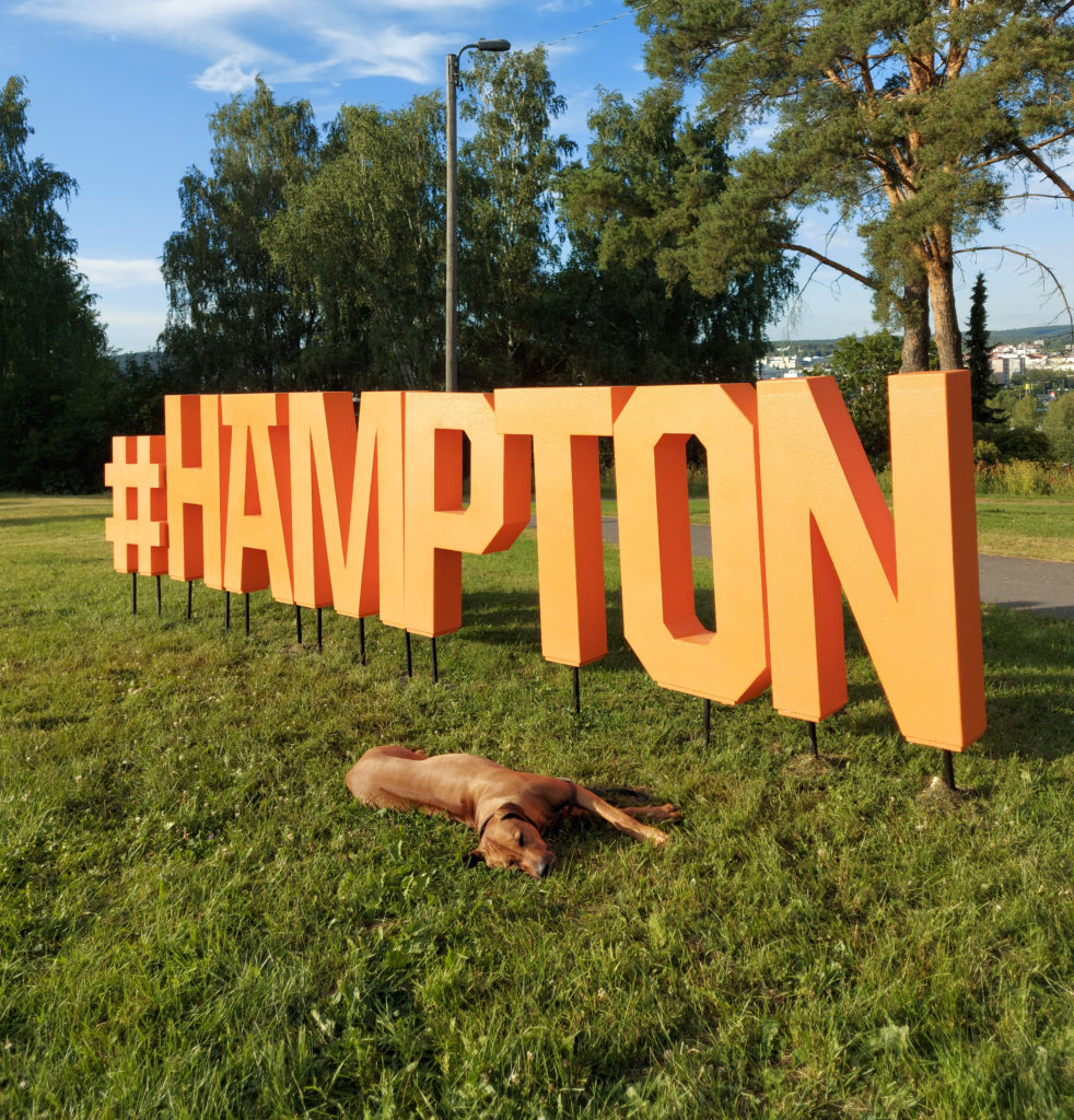 Kuvassa oranssit Hämpton kirjaimet puistossa.